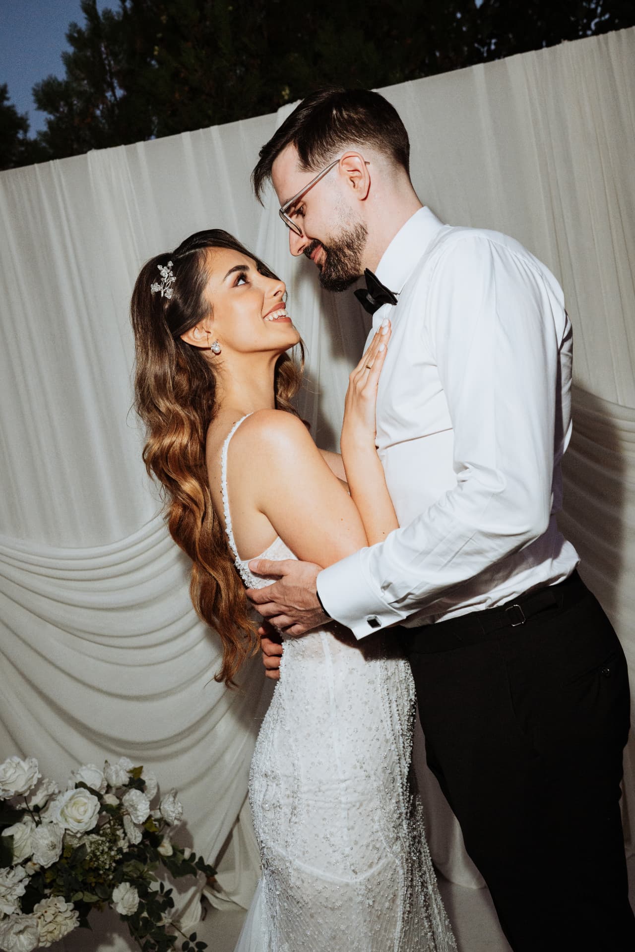 Evening portrait of Jelena looking up at Vladimir in front of draped white fabric